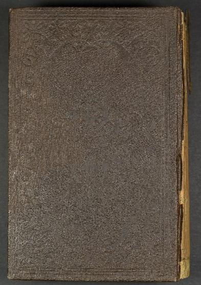 Brown leat她的 book cover with imprints that are barely visible, 左边可以看到一个未覆盖的旋转. 